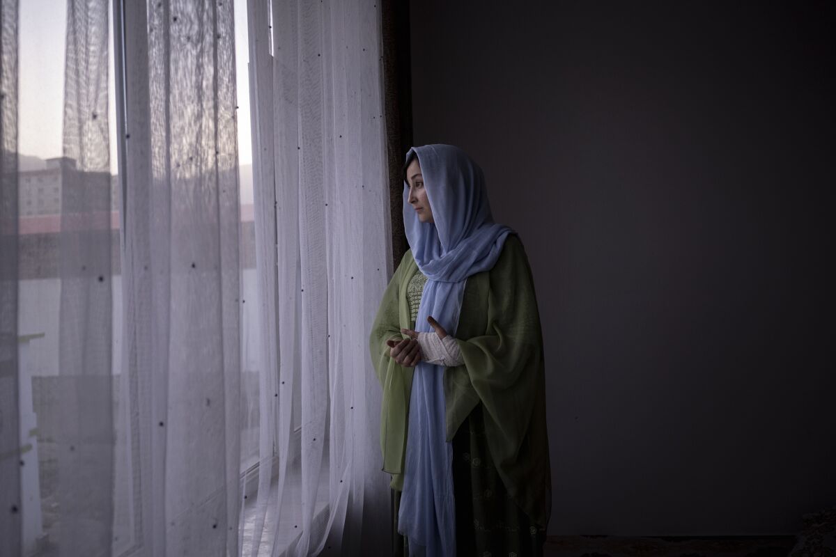 Rishmin Juyanda looks out of the window in Kabul, Afghanistan, Friday, Oct. 22, 2021. A rights activist, she is part of an underground network determined to fight repressive Taliban policies that limit the freedoms of women. (AP Photo/Bram Janssen)