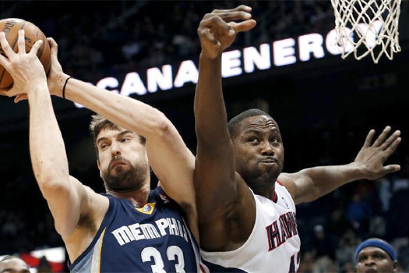 Memphis' Marc Gasol rips a rebound away from Atlanta's Elton Brand during the first half of a game on Feb. 8. Gasol had missed seven weeks because of a knee injury.