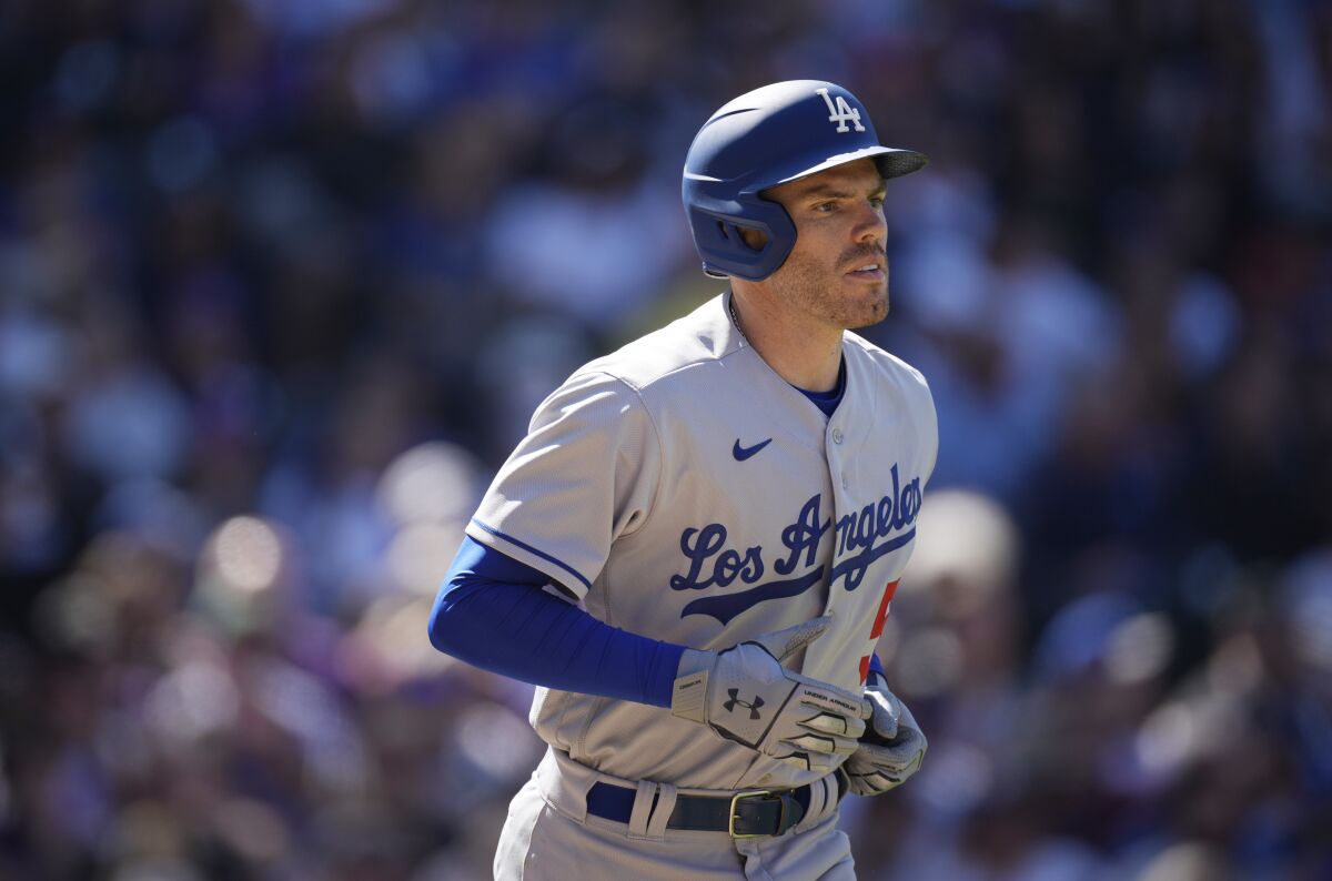 Los Angeles Dodgers' Freddie Freeman heads to first base after getting hit in the back by a pitch from Colorado Rockies starting pitcher Kyle Freeland in the third inning of a baseball game Friday, April 8, 2022, in Denver. (AP Photo/David Zalubowski)