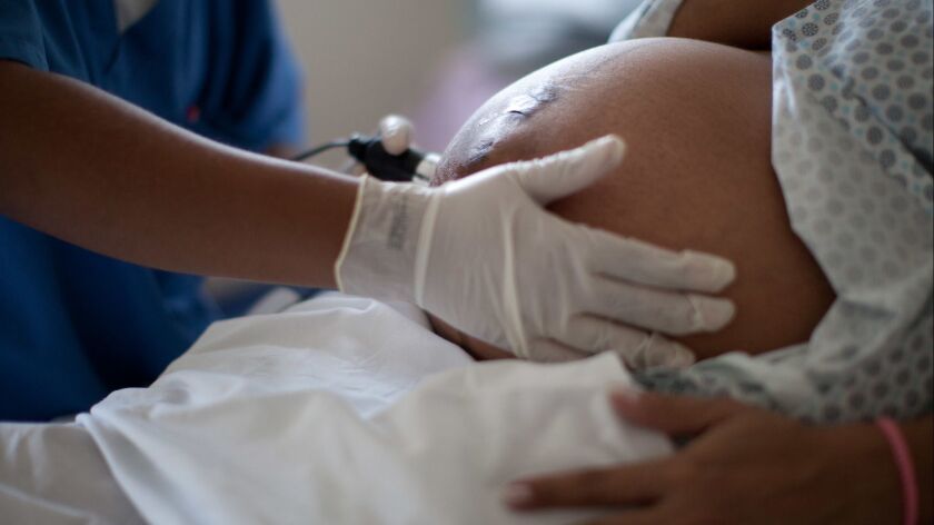A doctor examines a pregnant woman