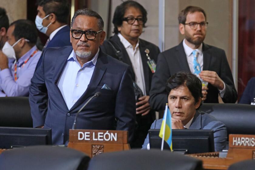 LOS ANGELES, CA - OCTOBER 11: Councilmember District 1 - Gil Cedillo, left, and Councilmember District 14 - Kevin de Leon, sitting right, at the Los Angeles City Council meeting at Los Angeles City Hall on Tuesday, Oct. 11, 2022 in Los Angeles, CA. Protestors want the resignation of Los Angeles Councilmembers Nury Martinez, Kevin de Leon and Gil Cedillo. Martinez made racist remarks about Councilmember Mike Bonin son in the recording as her colleagues, Councilmembers Kevin de Leon and Gill Cedillo, laughed and made wisecracks. (Gary Coronado / Los Angeles Times)