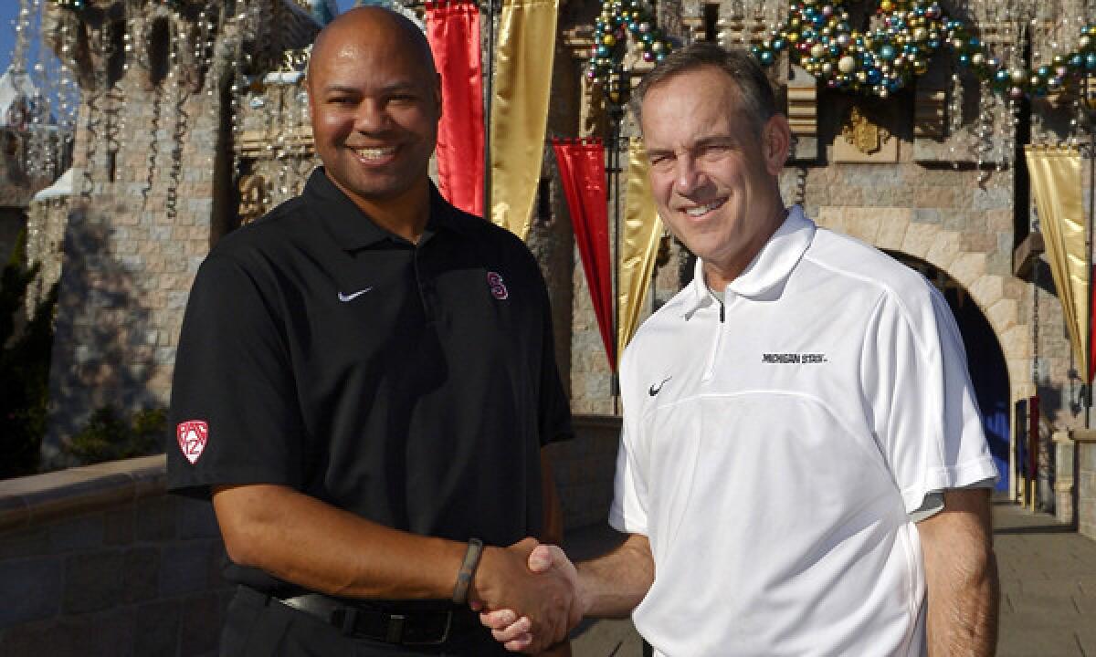 Stanford Coach David Shaw, left, and Michigan State Coach Mark Dantonio pose and shake hands during a visit to Disneyland on Thursday. The New Year's Day matchup between Michigan State and Stanford should make for a compelling Rose Bowl.