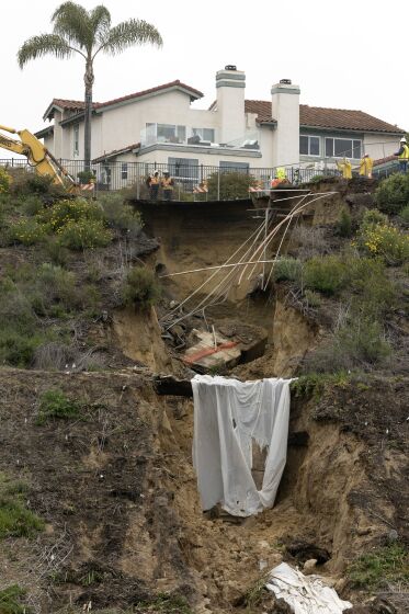 Runoff that caused a large sinkhole from recent rains flowed down a ravine at the south end of Lake Drive in Cardiff as work goes on to repair it on Saturday, March 11, 2023.