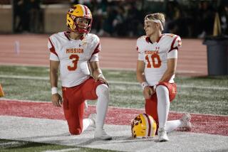 Mission Viejo quarterbacks Luke Fahey (left) and Draiden Trudeau on the sideline during a timeout Friday.