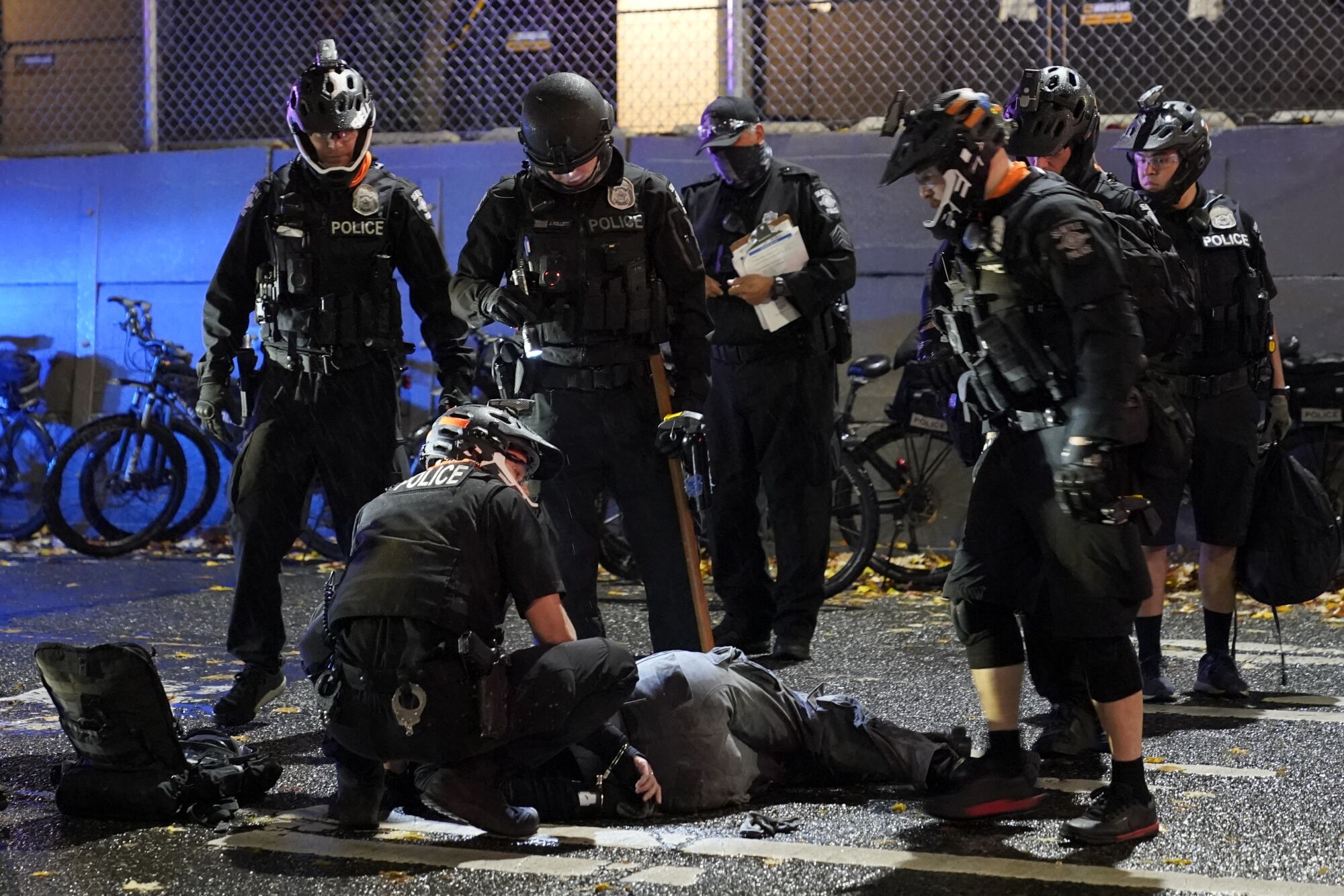 Police officials attend an injured man detained during a protest after the Nov. 3 elections in Seattle.