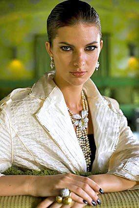 Cartier Inde Mysterieuse diamond earrings ($75,000); Caresse dorchidées diamond and pearl necklace, price on request. Bottega Veneta rings, from left: yellow gold diamond Sfera ring ($5,700), white pavé diamond Sfera ring ($6,250), yellow gold diamond Sfera ring ($6,250). Louis Vuitton silk embossed coat ($5,130).