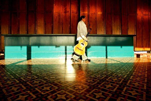 Guitarist Javier Roldan walks along an empty hallway of the Rosarito Beach Hotel in Rosarito, Mexico in late February. He plays in the restaurant of the hotel, where the occupancy is down to about 10%.