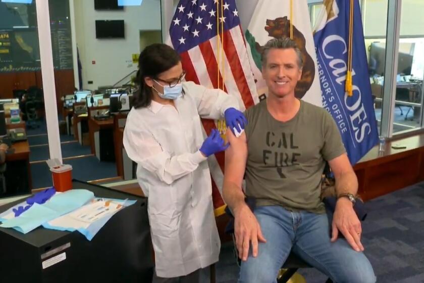 In this image taken from live streamed video from the California Governor's Office, California Gov. Gavin Newsom getting a flu shot during a news conference on Monday, Sept. 28, 2020, in Rancho Cordova, Calif. Newsom said he has gotten a flu shot every year "for as long as I can remember." He said it's important to get a flu shot this year to ensure hospitals are not overrun by a combination of flu and coronavirus cases. While California's coronavirus cases have been decreasing over the last several weeks, Newsom said Monday there is "some concern" that cases could increase over the next few weeks. (California Governor's Office via AP))