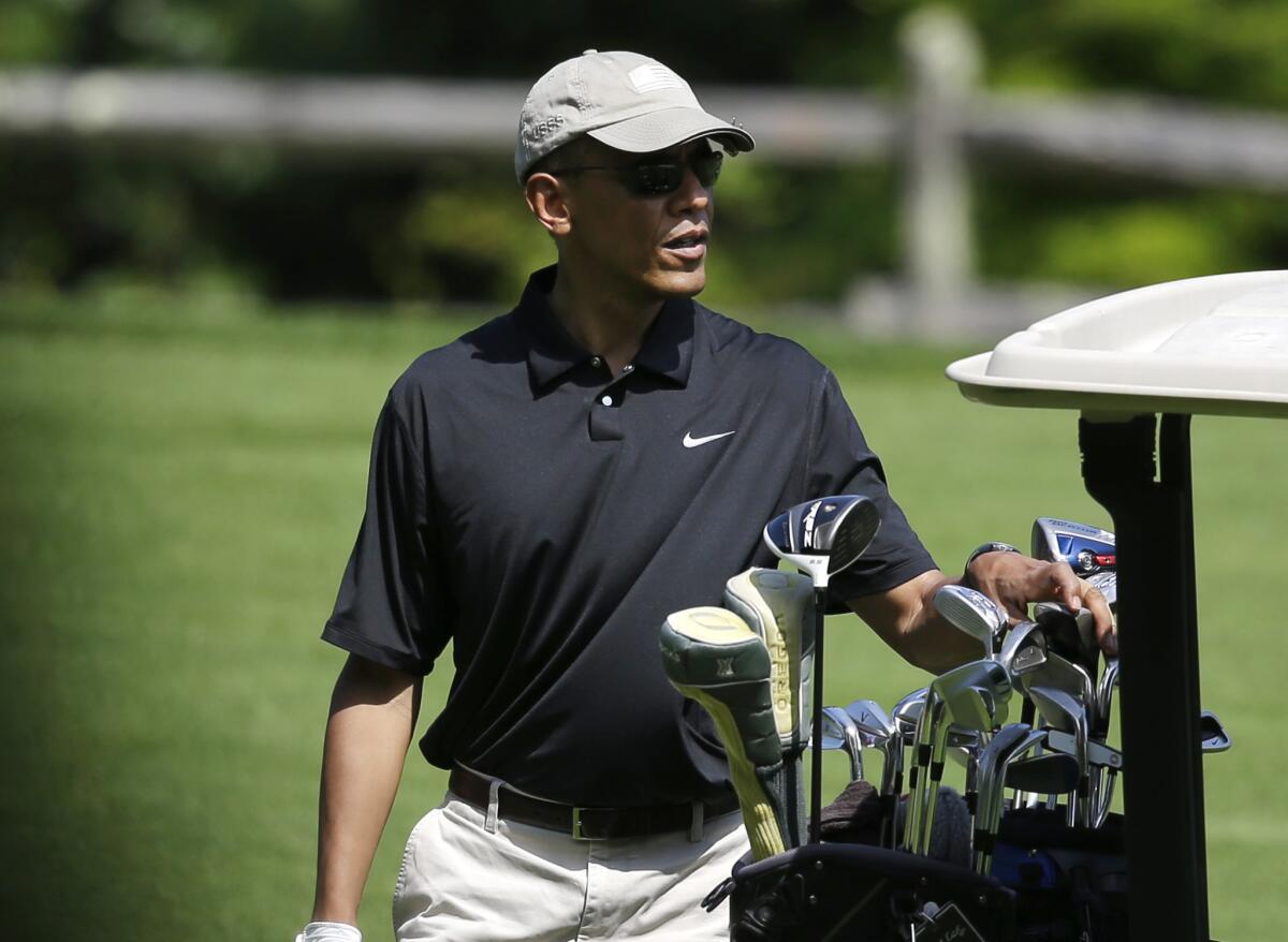 President Obama selects a club while golfing at Farm Neck Golf Club on Sunday. He also visited the Oak Bluffs, Mass., course on Saturday.