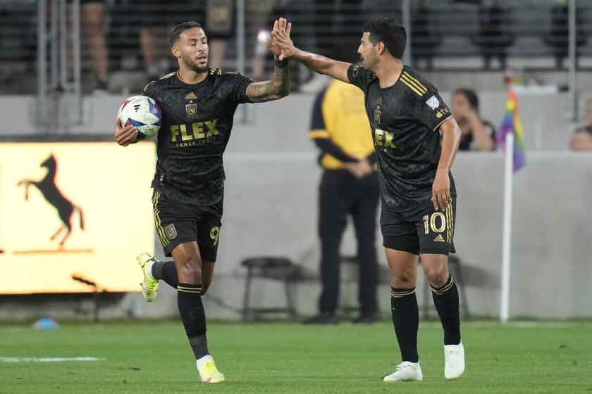 Los Angeles FC forward Denis Bouanga (99) celebrates with forward Carlos Vela (10) after scoring during the first half of an MLS soccer match against the Vancouver Whitecaps in Los Angeles, Saturday, June 24, 2023. (AP Photo/Ashley Landis)