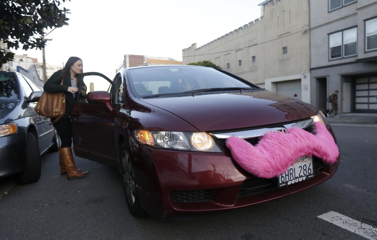 A passenger in San Francisco gets a ride through Lyft. Ride-sharing companies Lyft, Uber and Sidecar are being threatened with legal action in San Francisco and Los Angeles over how they screen drivers and charge passengers.