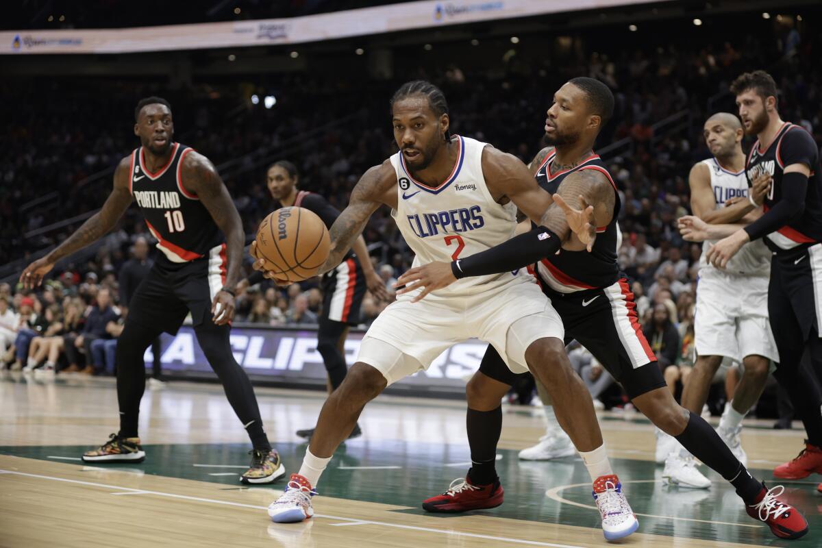 Clippers star Kawhi Leonard draws a foul from Portland Trailblazers point guard Damian Lillard.