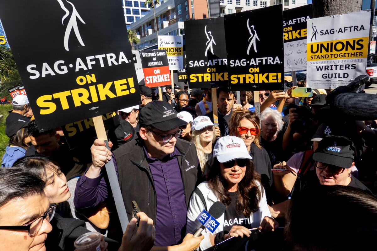 Picketers carry signs saying SAG-AFTRA on Strike.