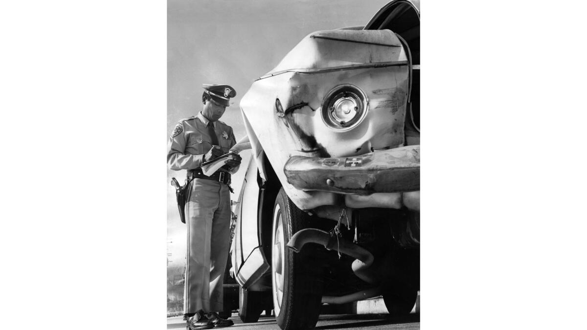 Dec. 22, 1966: California Highway Patrol Officer Edward Patterson writes a citation during a holiday traffic check on Sunset Boulevard.