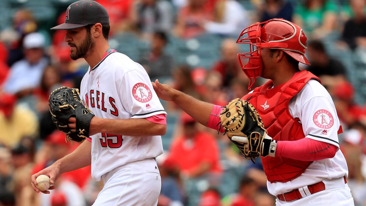 Angels pitcher Nick Tropeano is visited by catcher Carlos Perez during the first inning Sunday.