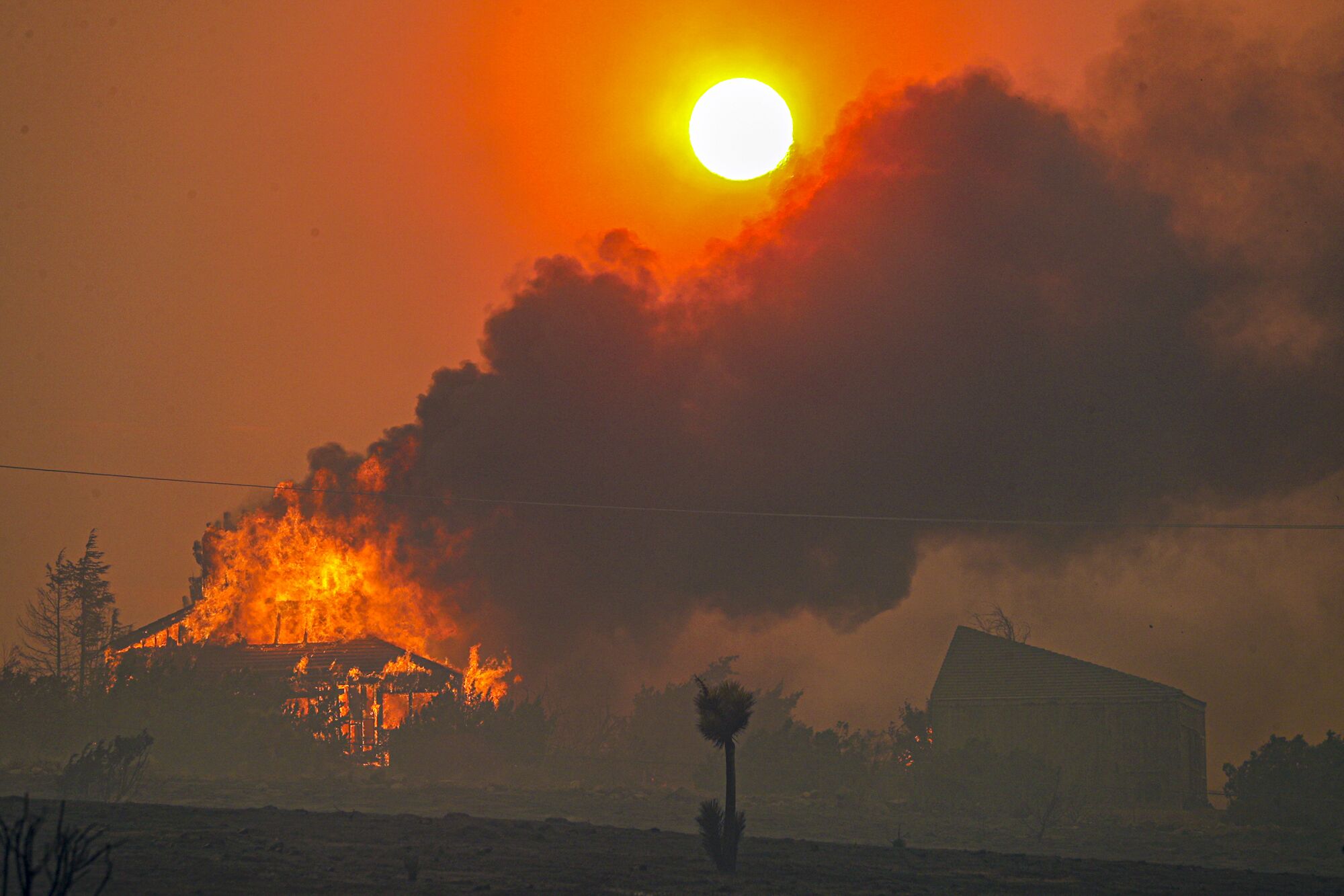 The setting sun is obscured by heavy smoke from the Bobcat fire as seen from Littlerock, Calif., on Friday.