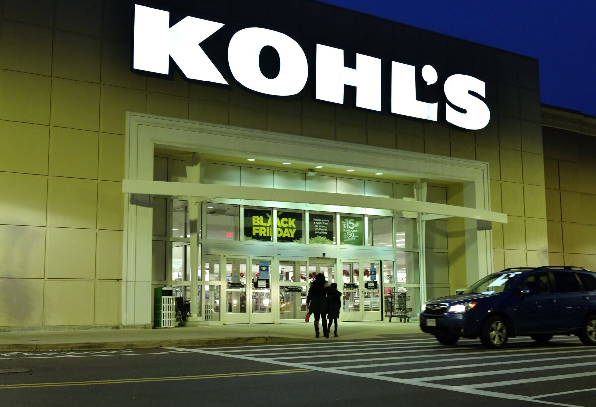 A pair of shoppers arrive at a Kohl's before dawn on Black Friday, Nov. 26, 2021, in Everett, Mass. An activist investor is pushing department store chain Kohl’s to either sell the entire company or spin off its e-commerce division. In a letter posted online on Monday, Dec. 6, 2021 Engine Capital said that it wants the Menomonee Falls, Wisconsin-based retailer to consider these alternatives to boost the stock price. (AP Photo/Josh Reynolds)
