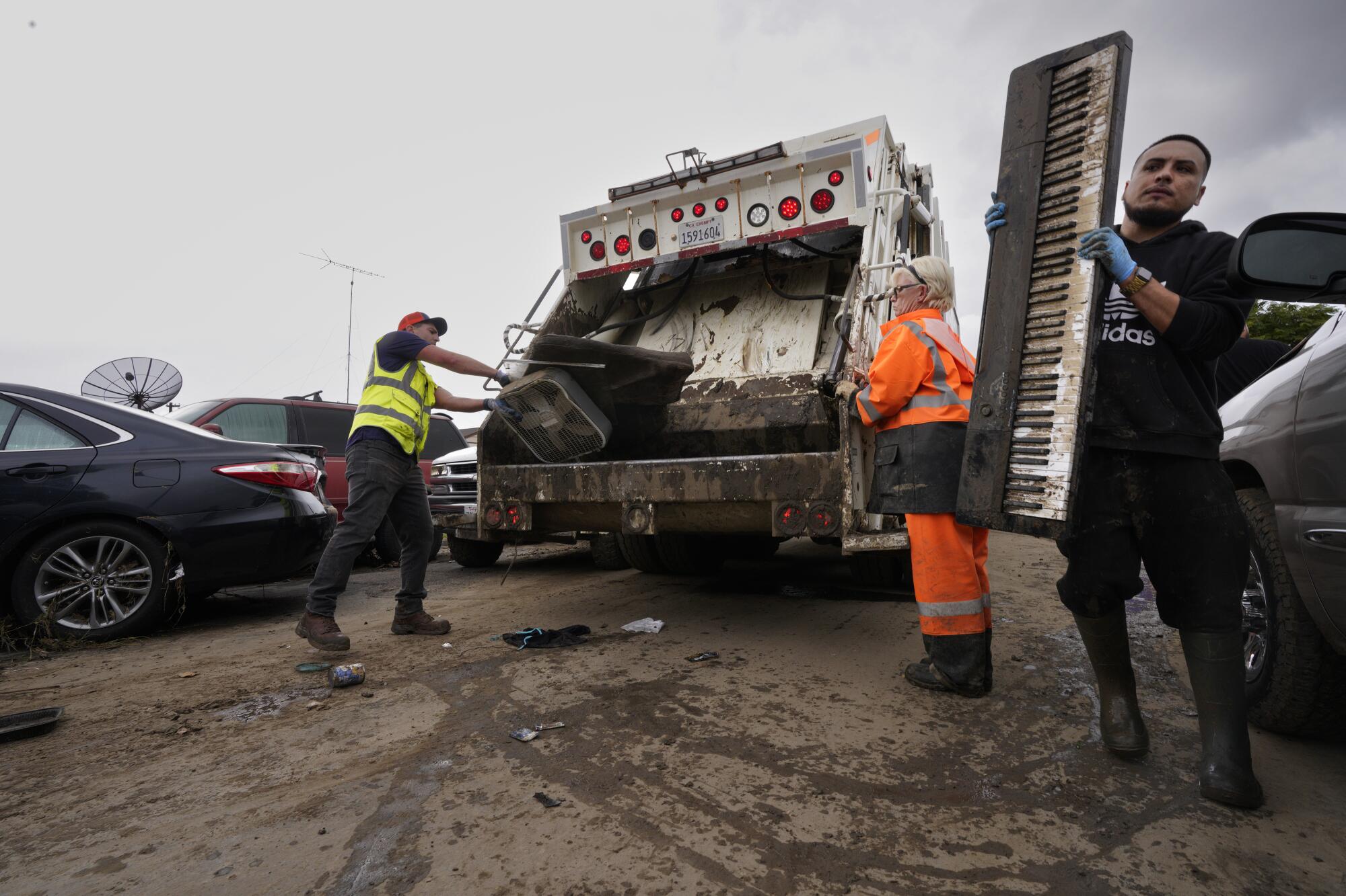 Cesar Sanchez, 28, carries a keyboard to landfill truck.
