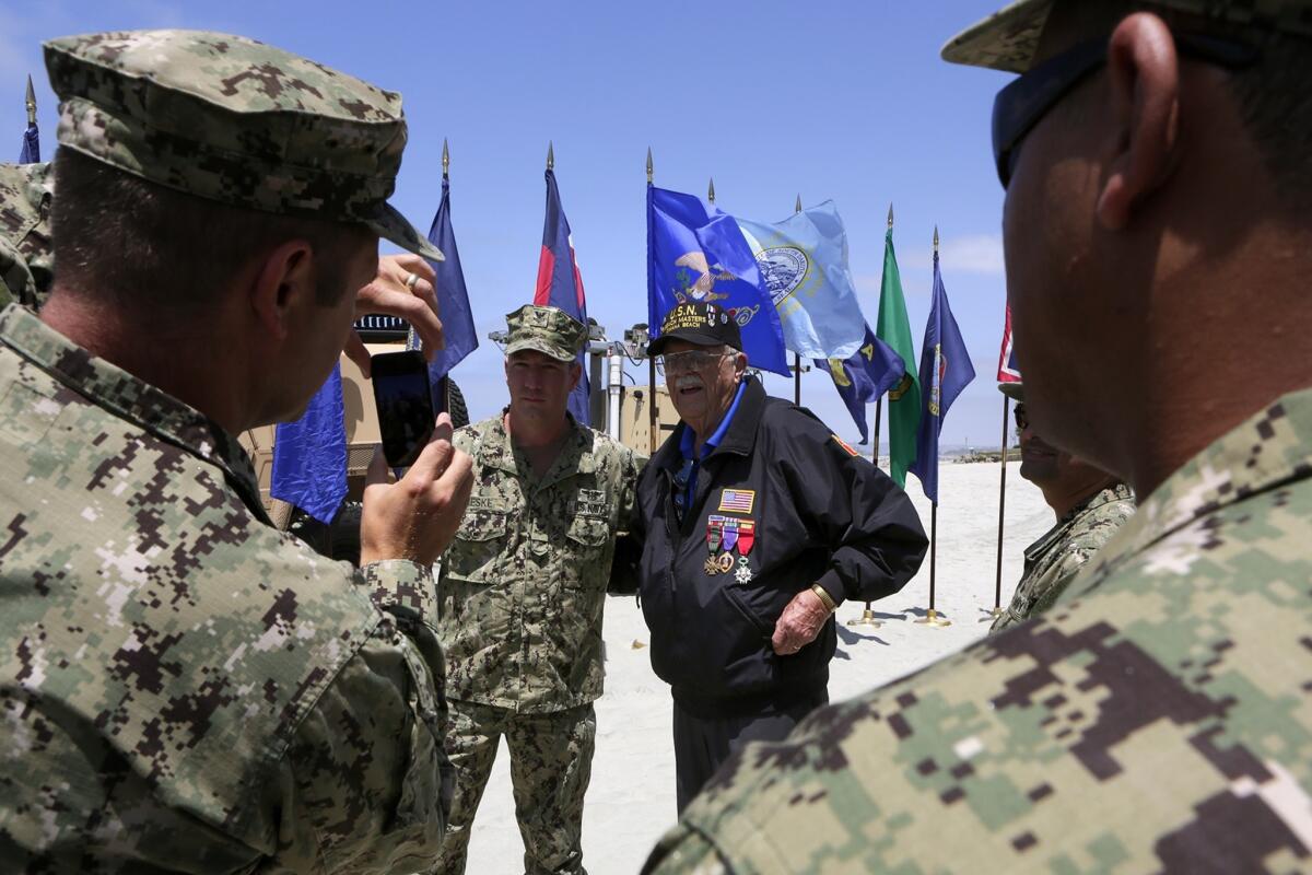 Sailors get their picture taken with Bob Watson, a D-day veteran, at a ceremony held by Beachmaster Unit 1 at Naval Amphibious Base Coronado to mark the 70th anniversary of the D-day landing at Normandy.
