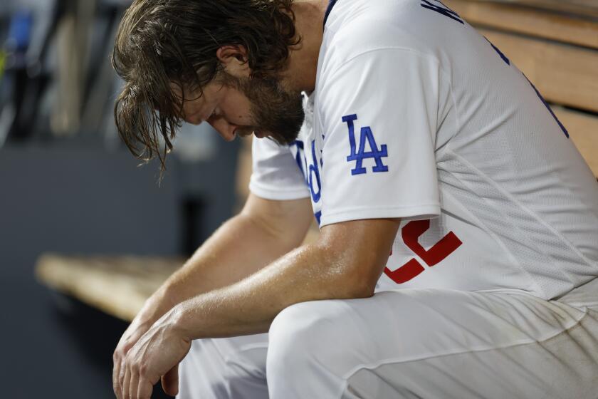 Dodgers pitcher Clayton sits on the bench after being pulled in the first inning Saturday against the Diamondbacks.