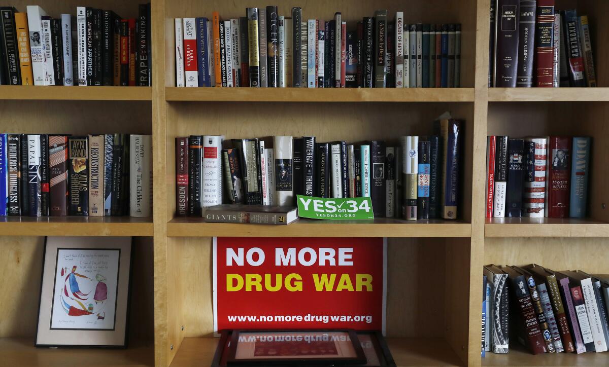 Shelves full on books and a sign that says "No more drug war."