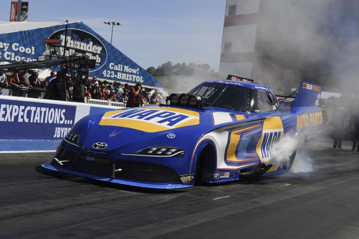 In this photo provided by the NHRA, reigning Funny Car champion Ron Capps collects a NHRA Thunder Valley Nationals drag races win in Bristol, Tenn., Sunday, June 19, 2022. ( Jerry Foss/NHRA via AP)