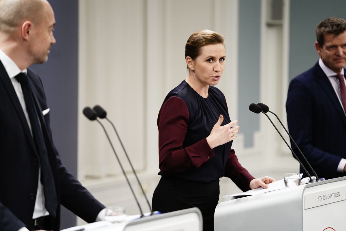 Denmark's Prime Minister Mette Frederiksen, takes part in a coronavirus press conference, with Minister of Health Magnus Heunicke, left, and director of the National Board of Health Soeren Brostroem, right, in Copenhagen, Denmark, Wednesday Jan. 26, 2022. (Mads Claus Rasmussen/Ritzau Scanpix via AP)