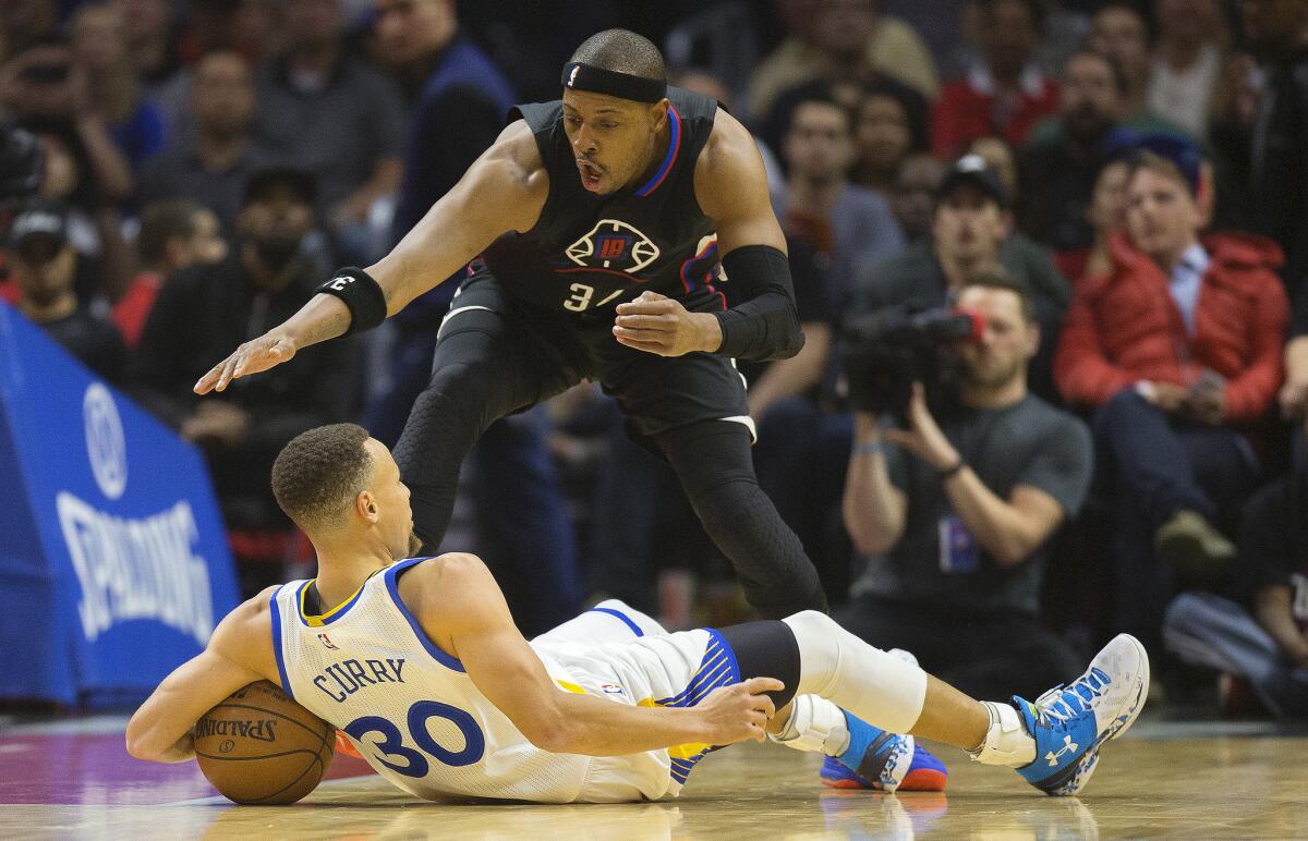 Clippers forward Paul Pierce goes for the ball after Golden State guard Stephen Curry loses his balance.