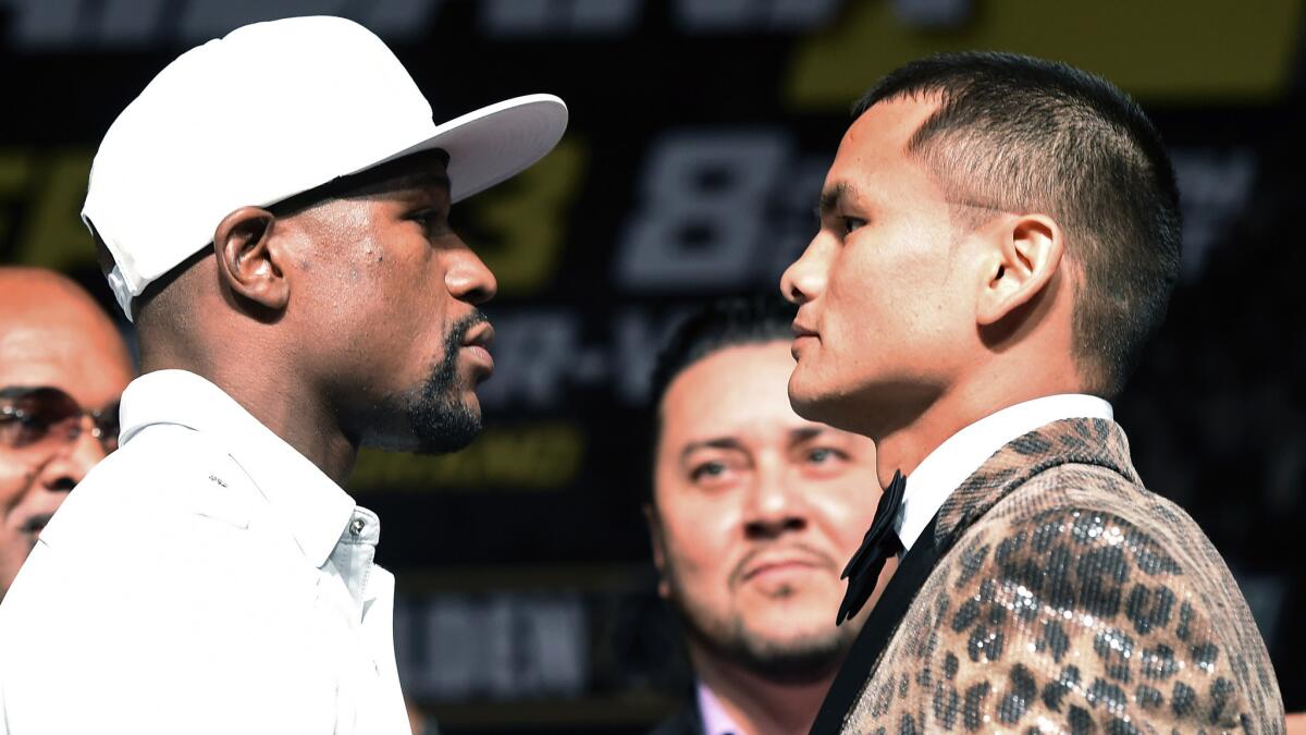 Floyd Mayweather Jr., left, and Marcos Maidana stare down one another during a news conference Wednesday in Las Vegas to promote their WBC/WBA welterweight championship bout Saturday.