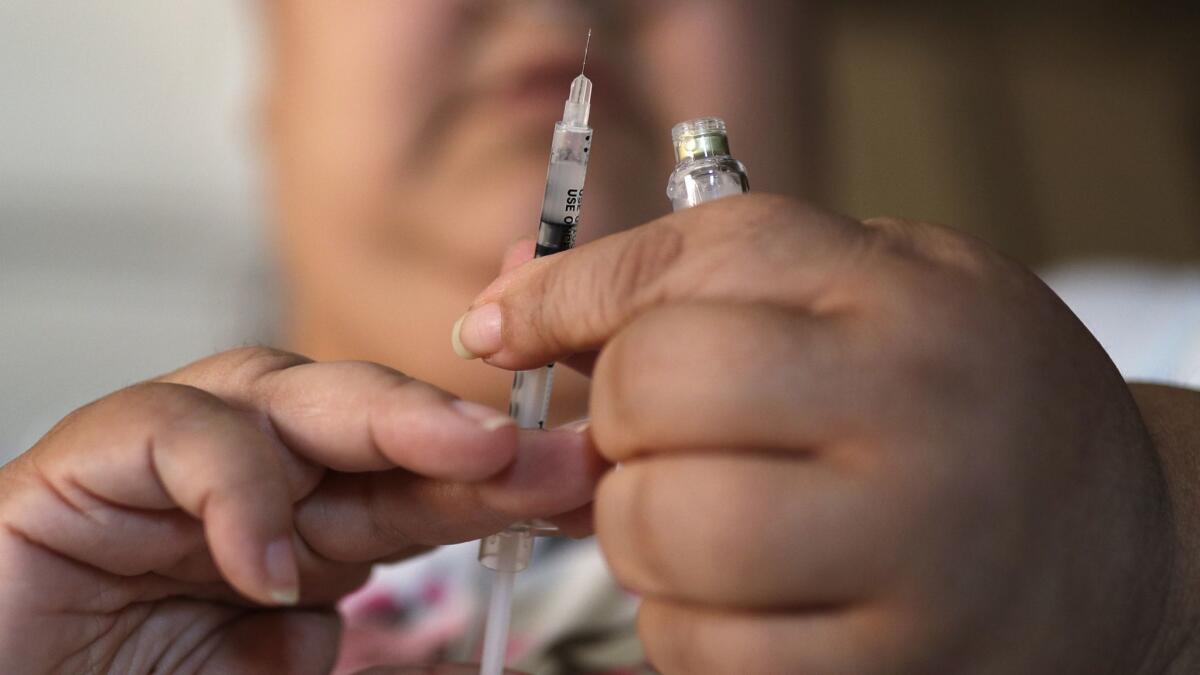 A woman with Type 2 diabetes prepares to inject herself with insulin. New federal data show that diabetes cases are falling, even though obesity continues to rise.
