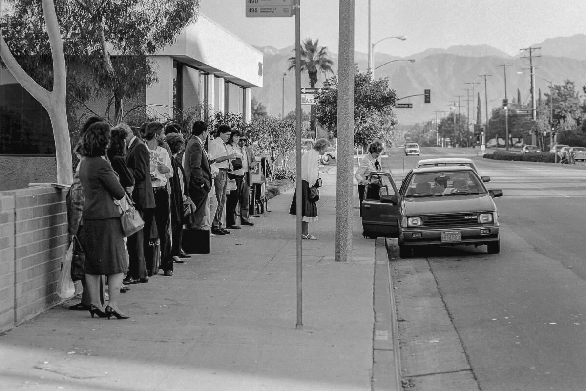 Nov. 12, 1987: A car driver picks up passengers at an express bus stop on Barranca Avenue in West Covina so they can take advantage of a freeway carpool lane.