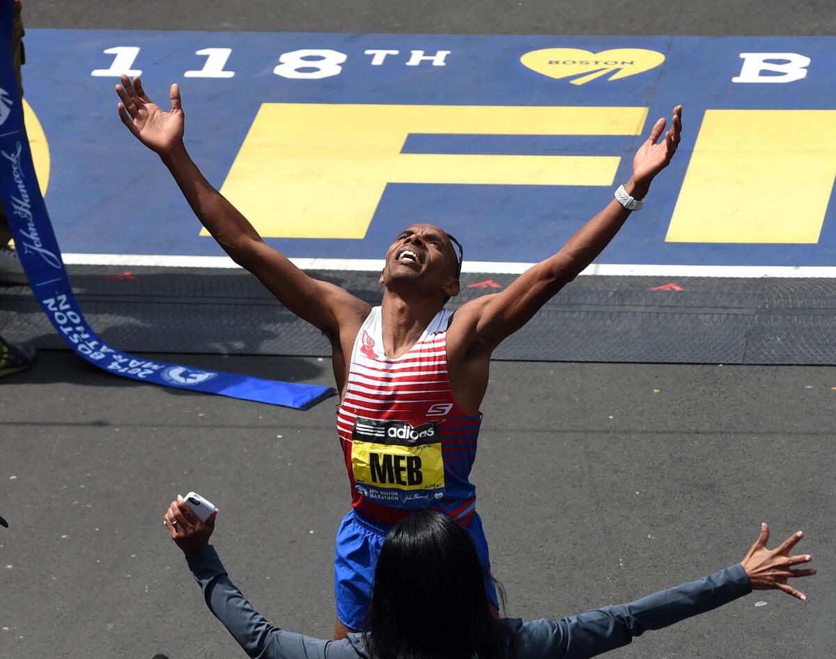 San Diego's Meb Keflezighi reacts as he crosses the finish line to win the 2014 Boston Marathon.