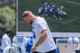 Rams defensive lineman Braden Fiske walks while looking down during practice.