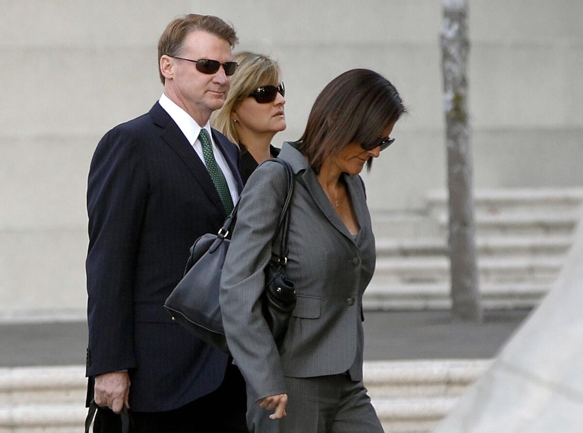 Former Deutsche Bank executive Brian Mulligan, left, arrives at court Tuesday with his wife Victoria, center.