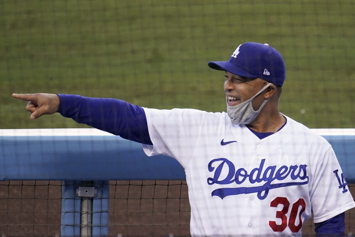 Dodgers manager Dave Roberts points in the dugout before a game.