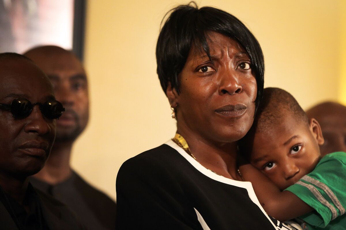 Ezell Ford's mother, Tritobia Ford, holds her son Zaire, 2, while speaking to reporters at the First AME Church of Los Angeles about the L.A. Police Commission's decision in her eldest son's fatal shooting. Ezell Ford was killed by LAPD officers in 2014.