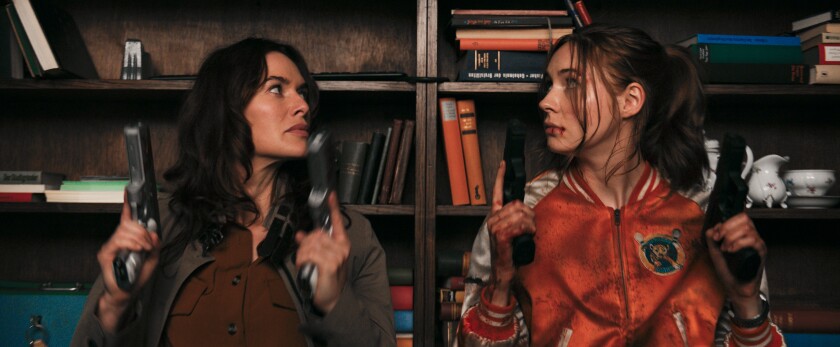 Two women each brandishing two handguns in the movie “Gunpowder Milkshake.”