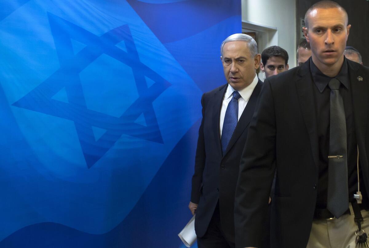 Israeli Prime Minister Benjamin Netanyahu, left, arrives at his Jerusalem office Sunday to attend a weekly Cabinet meeting.