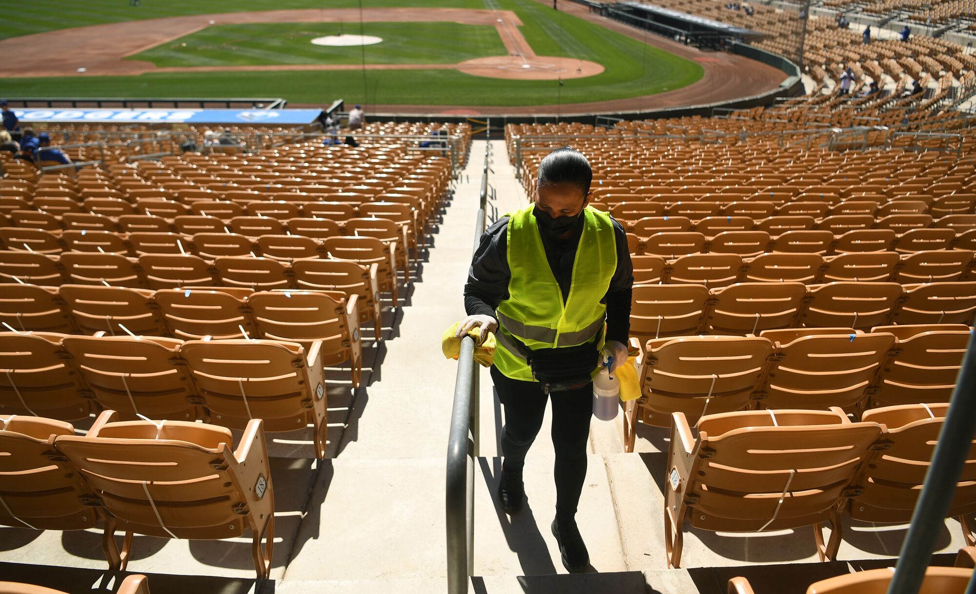 A worker wipes down a railing with disinfectant