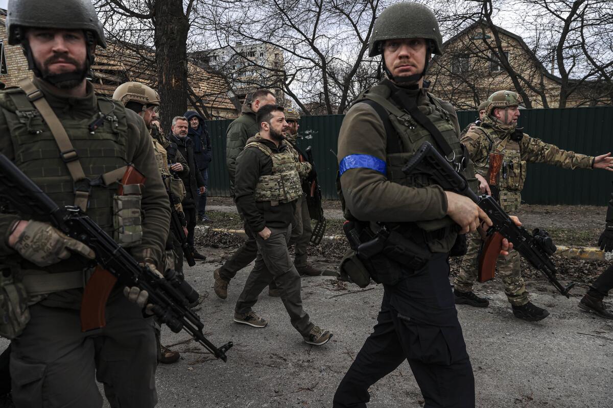 Ukrainian President Volodymyr Zelensky accompanied by Ukrainian soldiers.