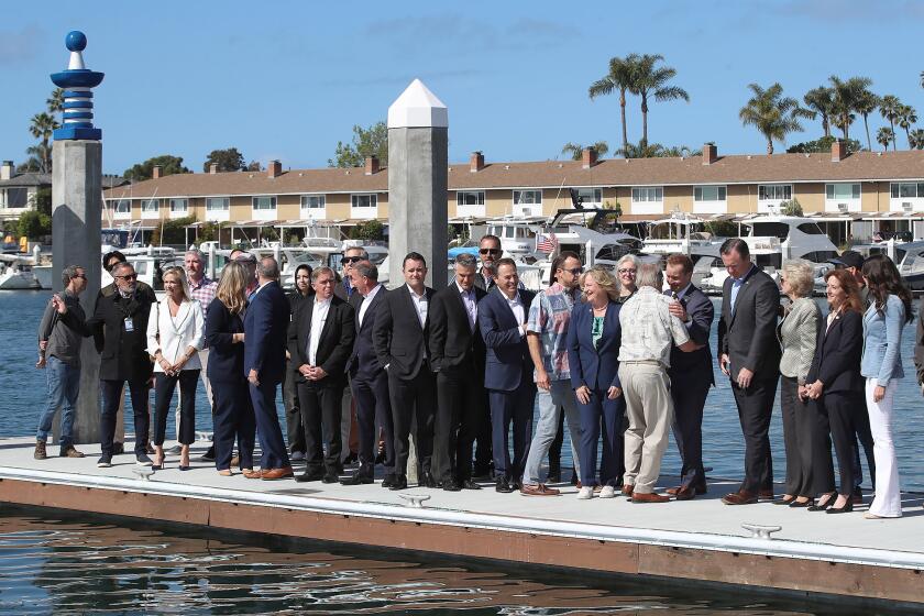 The city of Newport Beach, representatives from the County of Orange and the Irvine Company, stand on the dock of the Balboa Marina Public Pier during ribbon-cutting ceremony of the newest and largest public pier in Newport Harbor in Newport Beach on Friday.