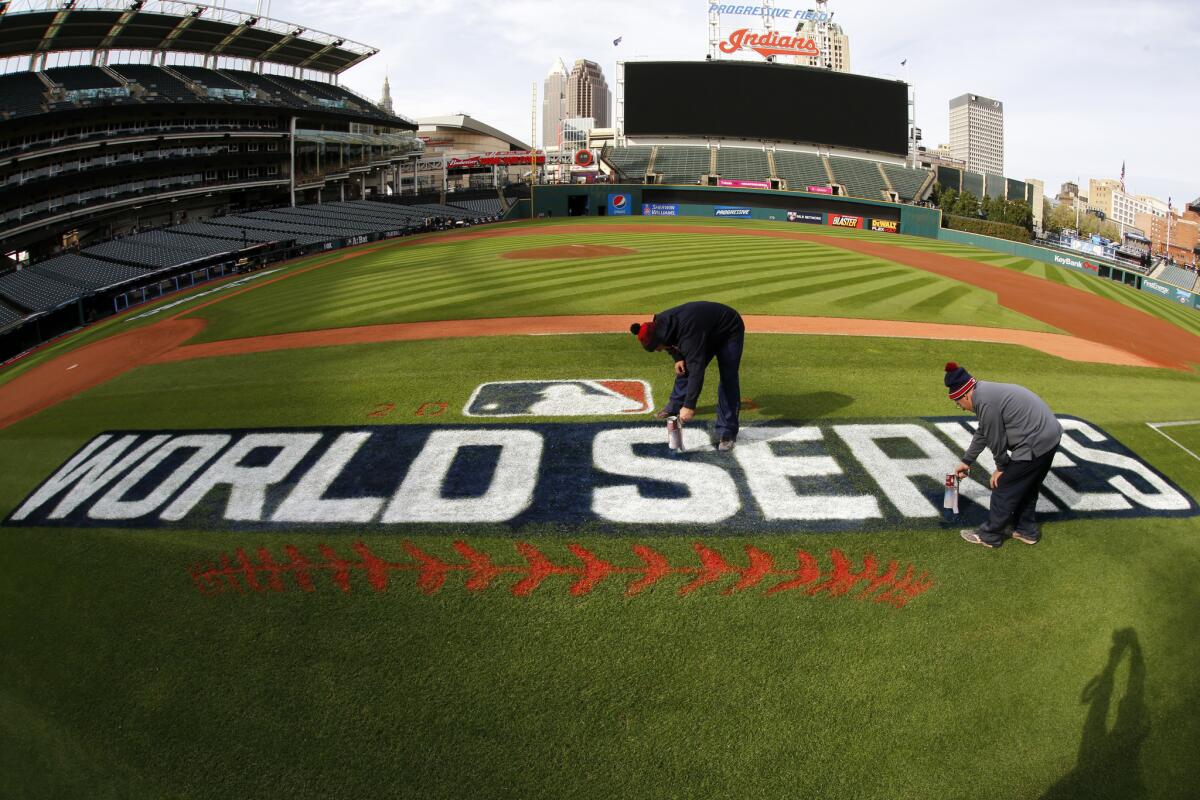 John Dileo, right, and Mathew Gudin of the Progressive Field ground crew paint touch up the World Series logo along the first baseline Monday, Oct. 31, 2016 in preparation for Tuesday night's game six of the World Series between the Cleveland Indians and Chicago Cubs in Cleveland. (AP Photo/Gene J. Puskar)