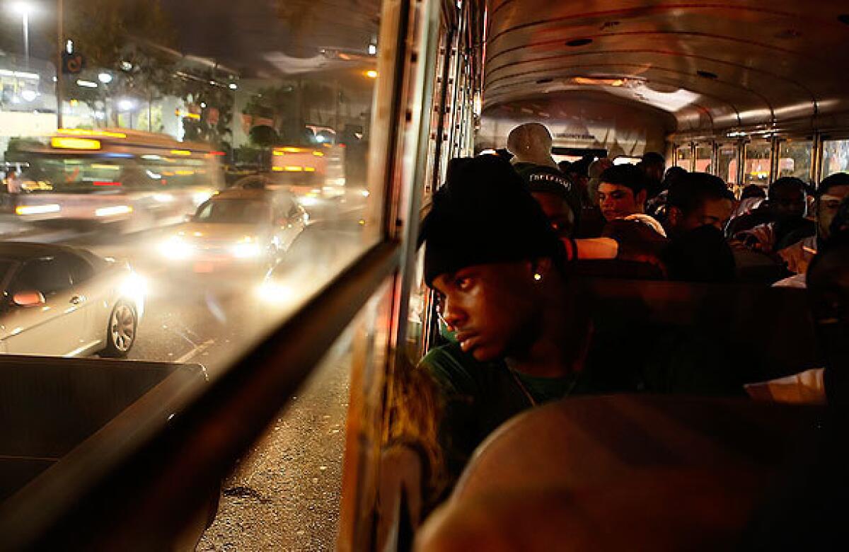 Members of the Dorsey High football team ride the bus down Crenshaw Boulevard in South Los Angeles, escorted by police, to face rival Crenshaw High. They're the last two predominantly black high schools in an increasingly Latino city, and their annual gridiron match-up splits friends and neighbors and sometimes city blocks, red against blue, Blood against Crip. > > > Audio slide show