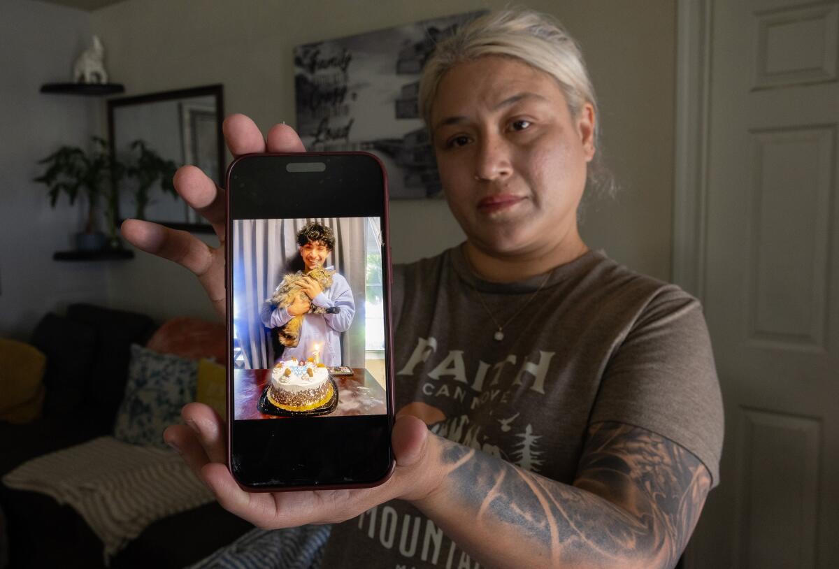 Myra Villarreal holds up a cellphone photo of son Adrian Andrew Martinez