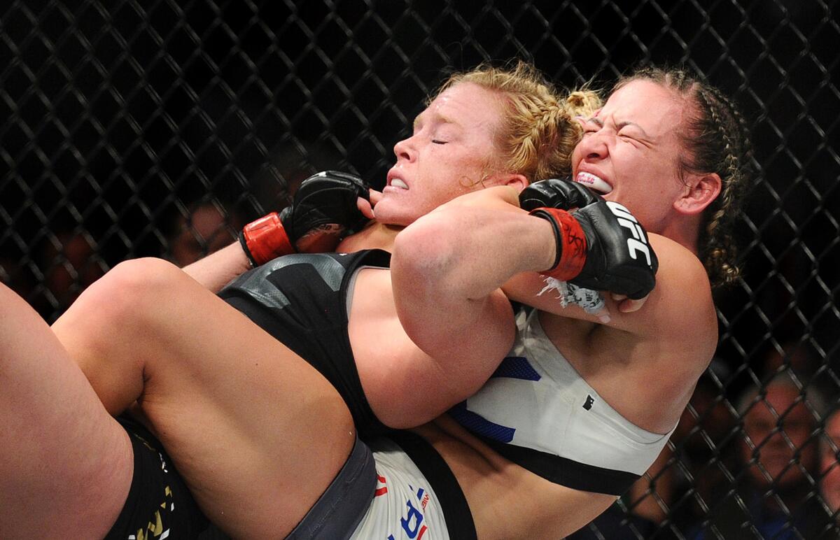 Miesha Tate sinks the chokehold on Holly Holm that led to a submission in the fifth round of their women's bantamweight championship fight at UFC 196 on Saturday night in Las Vegas.
