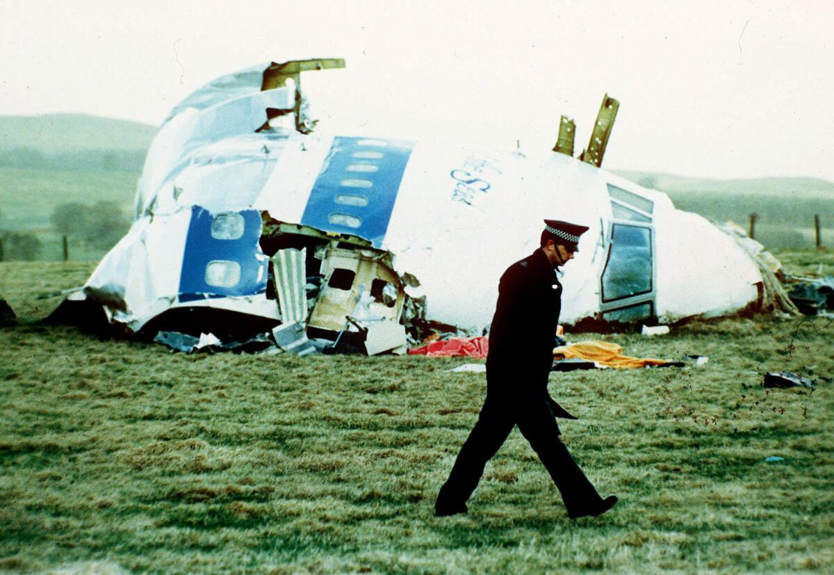 A police officer walks past the wreckage of the nose of Pan Am Flight 103 near Lockerbie, Scotland, on Dec. 21, 1988. A bomb aboard the Boeing 747 brought down the plane and killed 270 people.