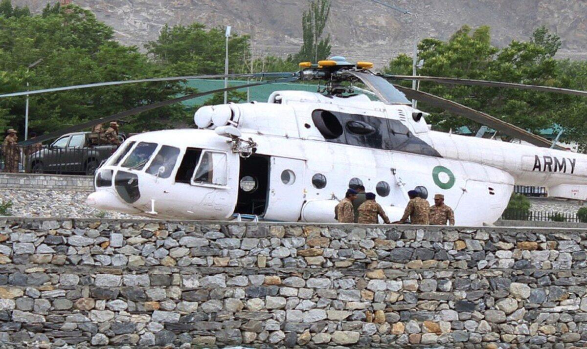 Pakistani soldiers gather near an army helicopter at a military hospital in Gilgit where victims of a helicopter crash were taken for treatment.