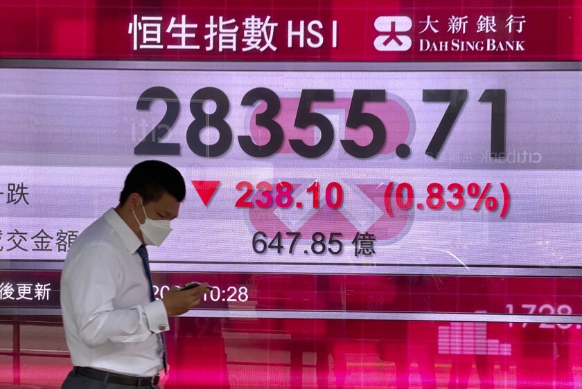 A man walks past a bank's electronic board showing the Hong Kong share index at Hong Kong Stock Exchange Thursday, May 20, 2021. Shares were mixed in Asia on Thursday after benchmarks closed broadly lower on Wall Street in a third day of retreat. (AP Photo/Vincent Yu)