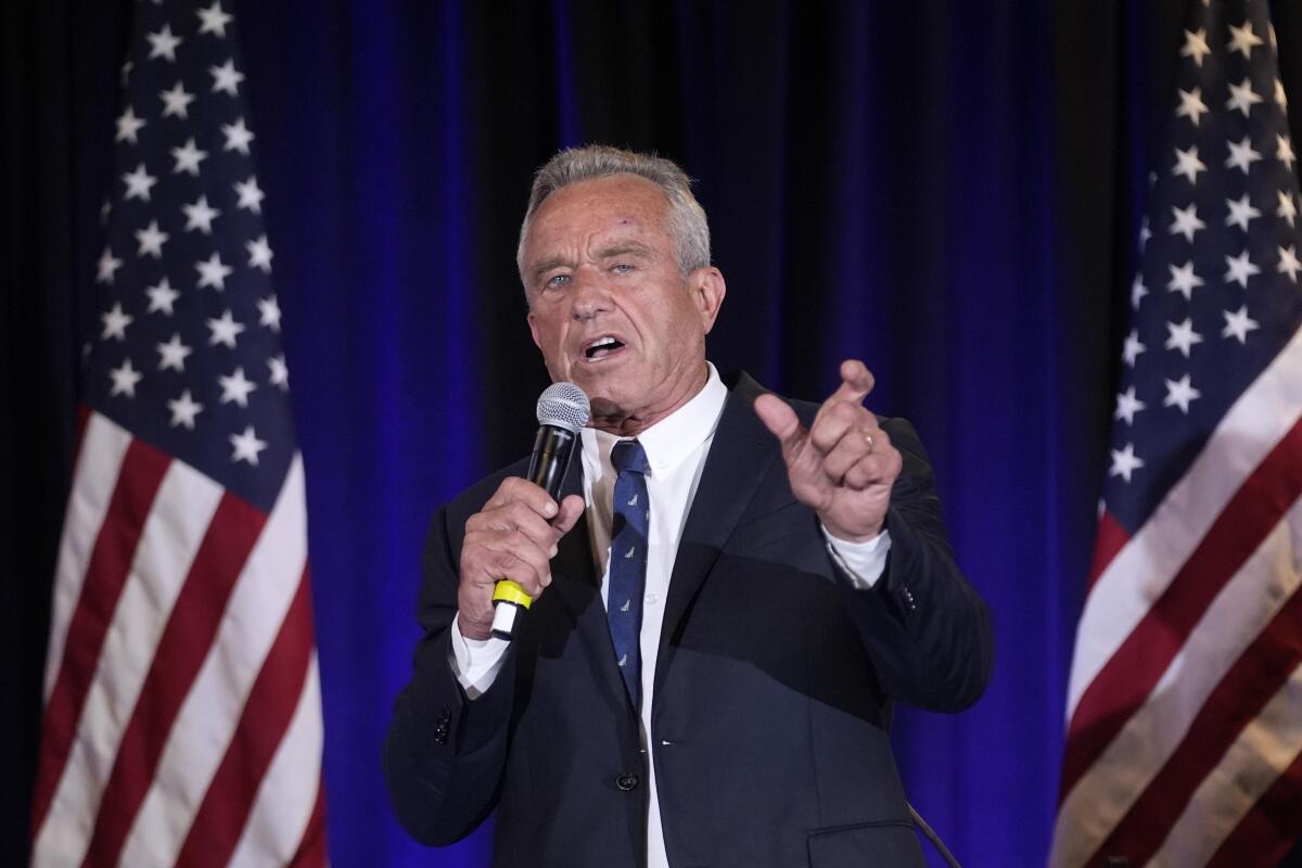 Robert F. Kennedy Jr. holds a microphone and speaks.