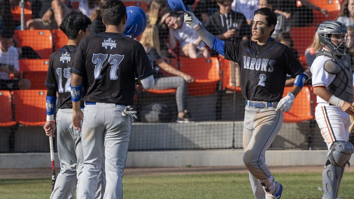 Fountain Valley High's Sebastian Murillo gets high-fives after hitting a three-run home run in the fourth inning at Huntington Beach on Wednesday.